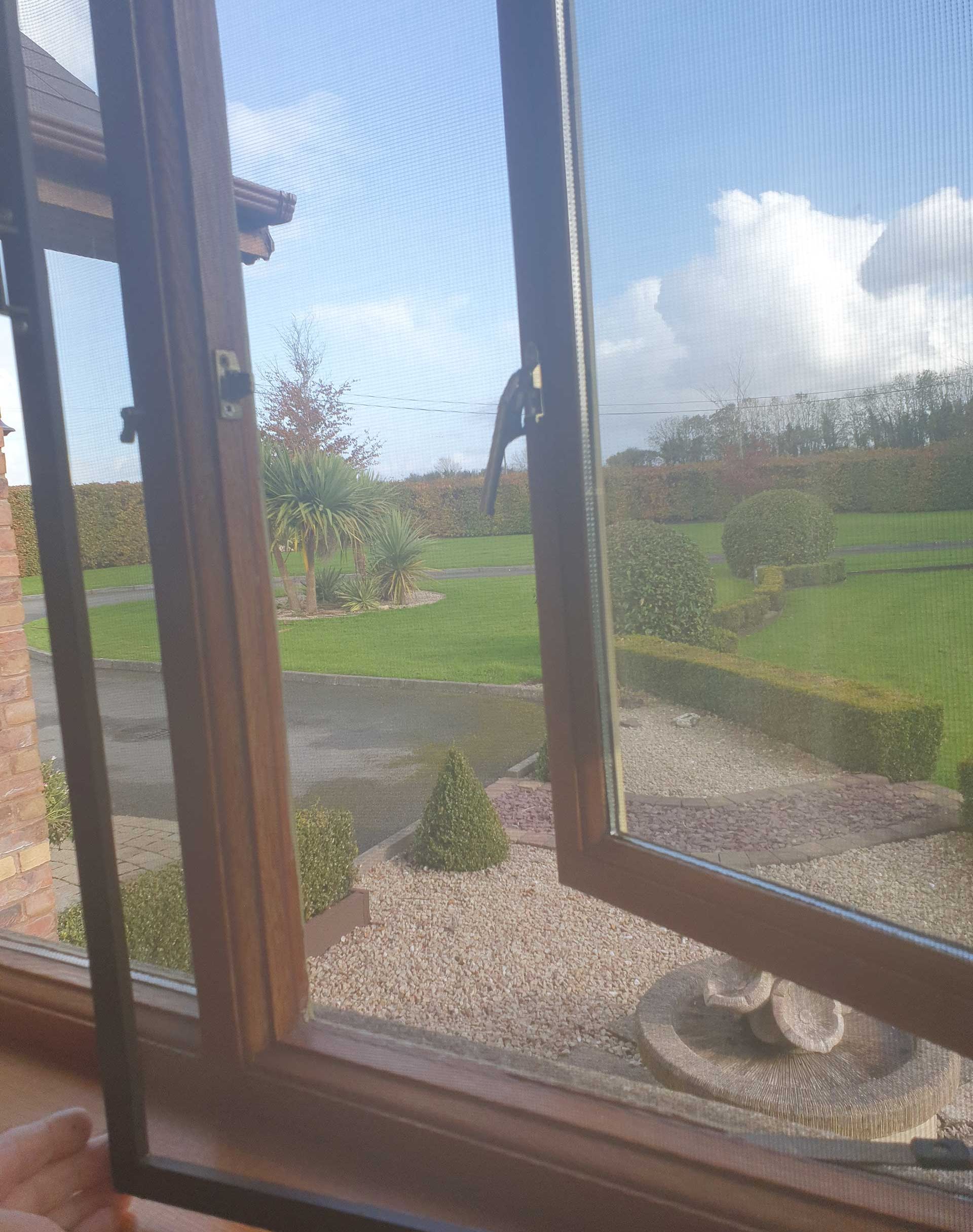 transparent fly screen installed over a window screen